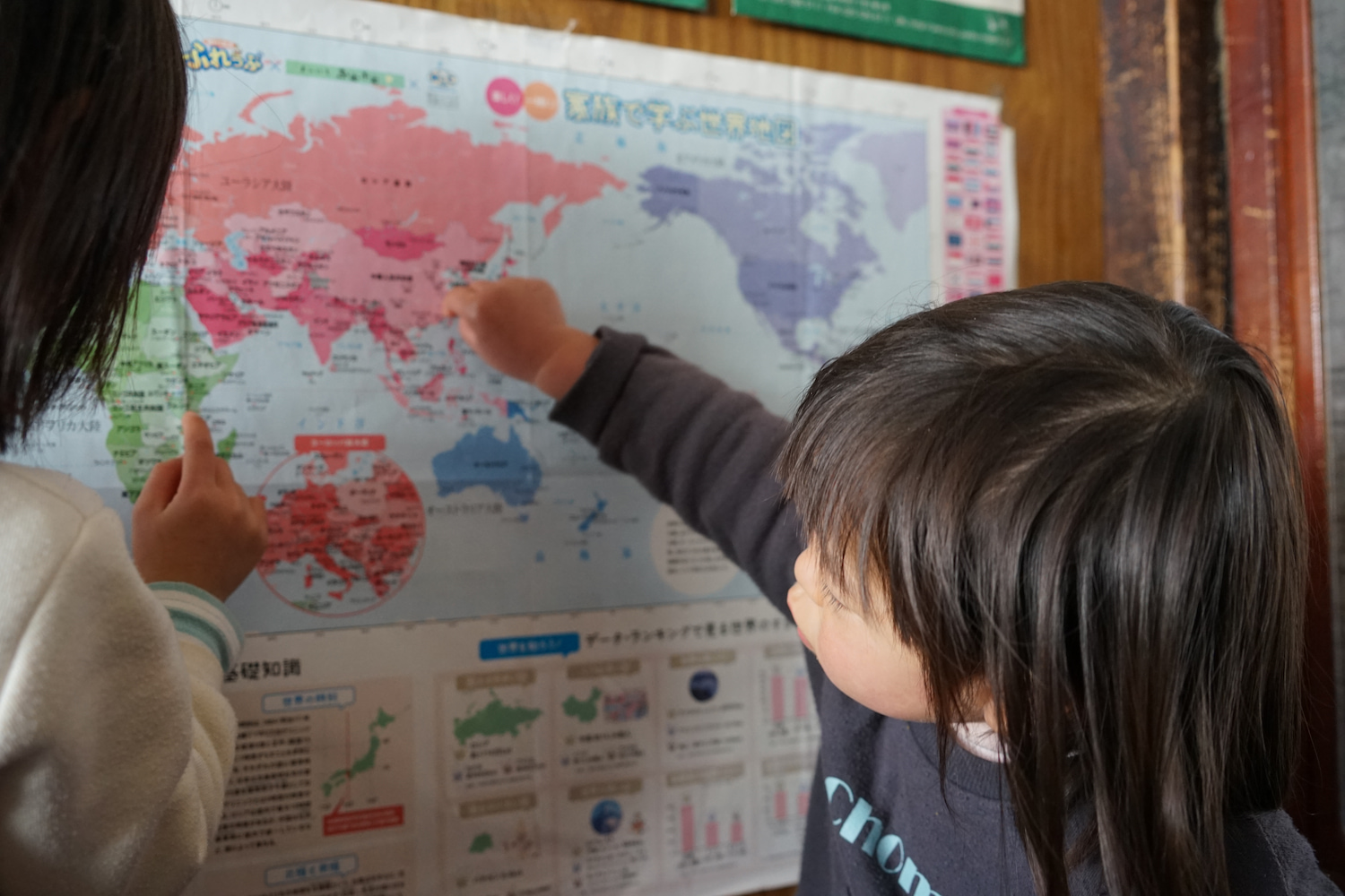 世界地図を見る2人のお子さん。